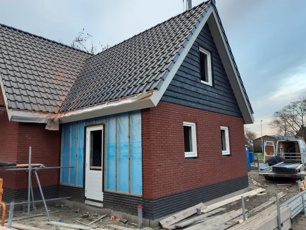 De aanbouw wordt ondergeschikt gemaakt aan de hoofdbouw.